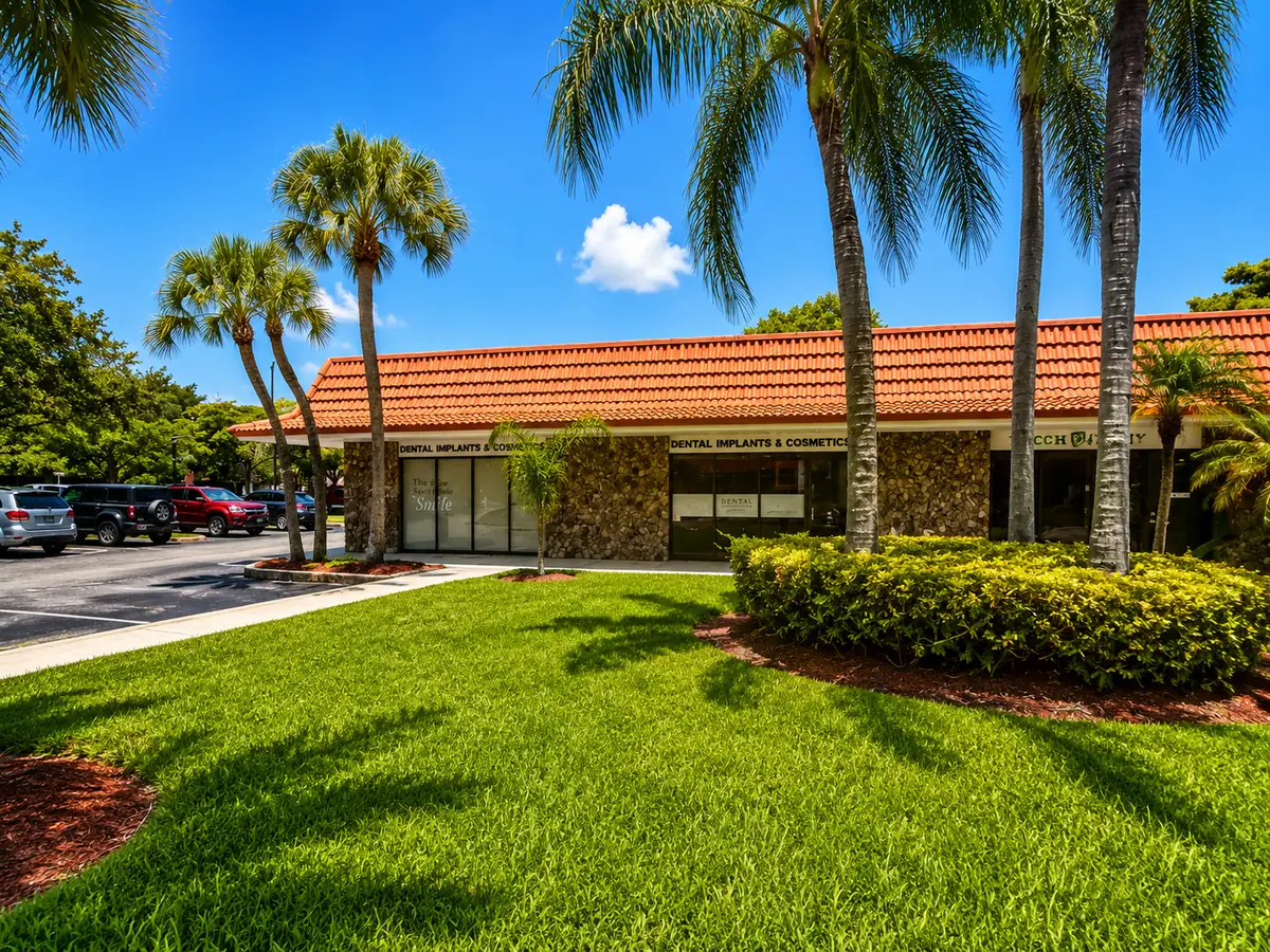 Front facade of Dental Implants and Cosmetics with Spanish tile roof and stone exterior in Plantation, FL
