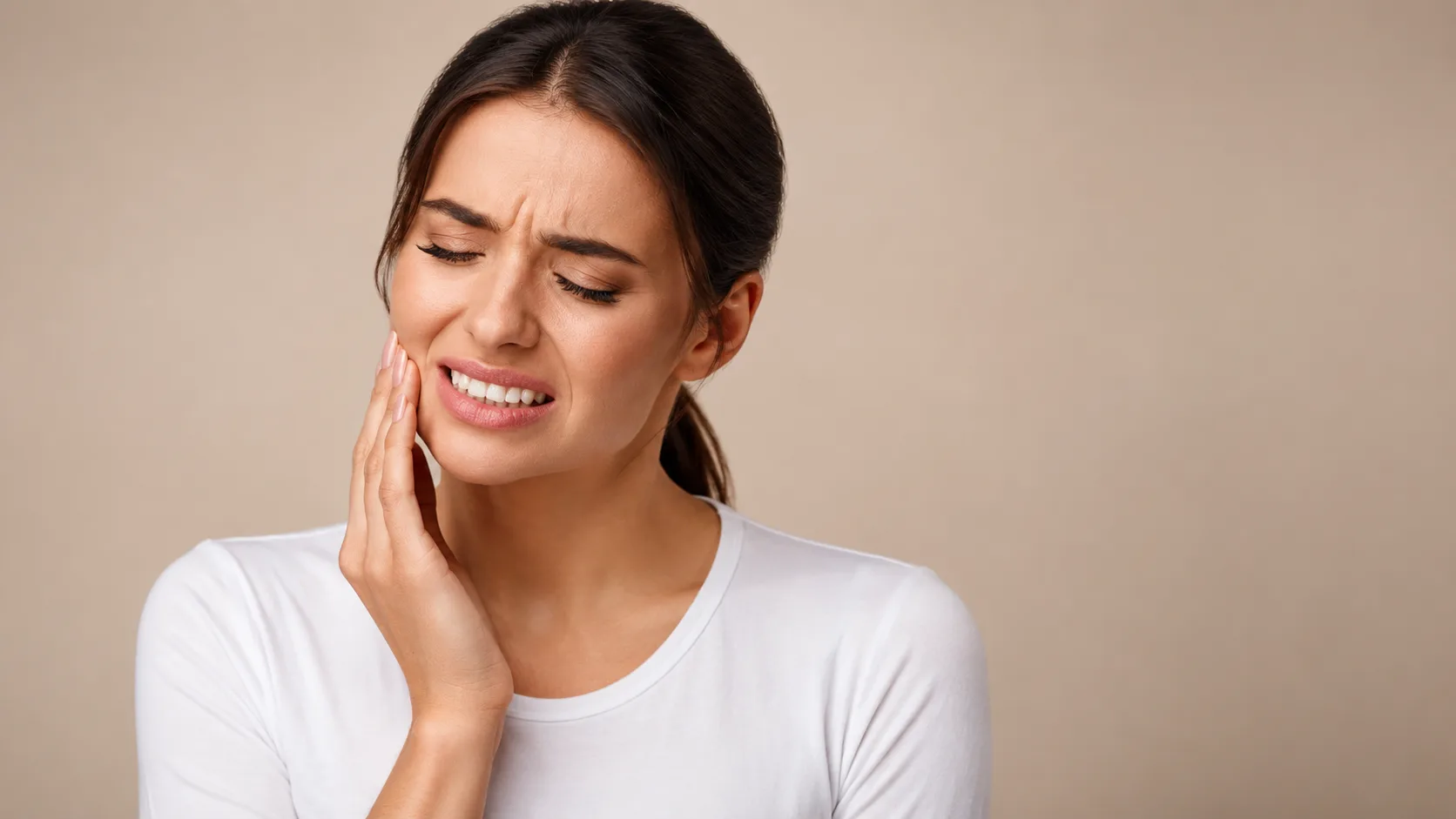 Woman experiencing dental pain holding her jaw